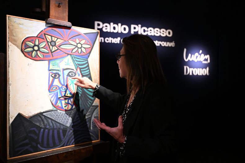 La experta en arte Agnes Sevestre-Barbe señala un cuadro de Picasso redescubierto, Busto de mujer con sombrero floreado, el miércoles 22 de octubre de 2025 en París. El retrato, creado en 1943 y subastado el viernes en París, fue adquirido en 1944 y muestra a su pareja, Dora Maar. (Foto AP/Emma Da Silva)