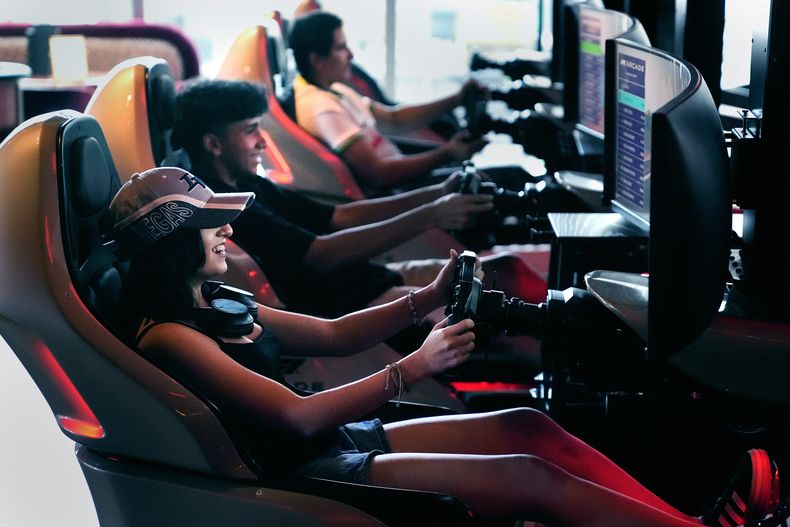 Brianna Restrepo, de Revere, Massachusetts, sonríe mientras compite con amigos en el F1 Boston Arcade, el lunes 8 de julio de 2024, en Boston. (AP Foto/Charles Krupa)