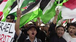 Manifestantes corean consignas mientras ondean banderas palestinas durante una marcha en apoyo del pueblo palestino en el exterior de la misión de Naciones Unidas en Yakarta, Indonesia, el 20 de octubre de 2023. (AP Foto/Dita Alangkara)