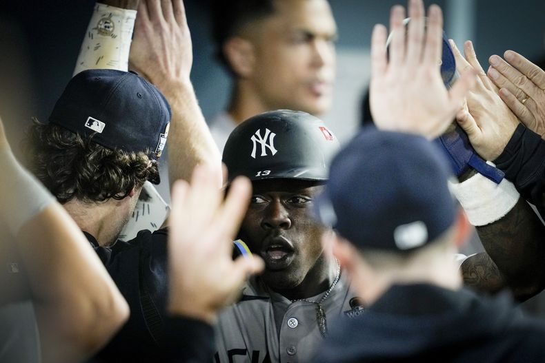 Jazz Chisholm Jr., de los Yankees de Nueva York, festeja en la cueva luego de anotar en bola ocupada ante los Dodgers de Los Ángeles, en el primer juego de la Serie Mundial, el viernes 25 de octubre de 2024 (AP Foto/Ashley Landis)
