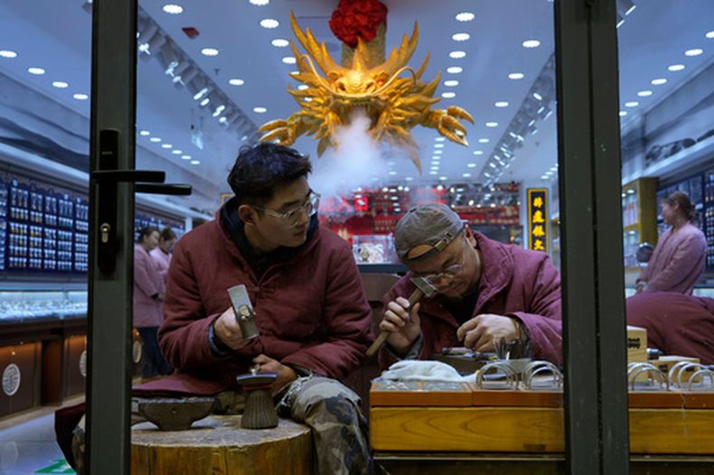 Trabajadores fabrican joyería de playa en una tienda en Beijing, el jueves 18 de diciembre de 2025. (AP Foto/Ng Han Guan)
