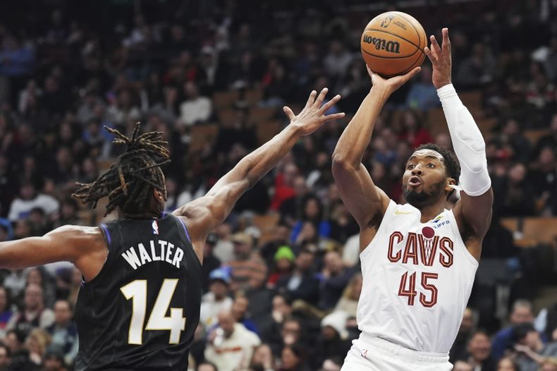 Donovan Mitchell (45), de los Cavaliers de Cleveland, dispara a la canasta sobre JaKobe Walter (14), de los Raptors de Toronto, durante la primera mitad del juego de baloncesto de la NBA, el miércoles 12 de febrero de 2025, en Toronto. (Frank Gunn/The Canadian Press vía AP)