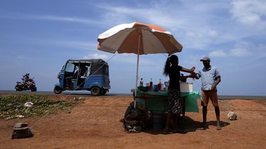 Un hombre compra una bebida refrescante de un vendedor ambulante en un día soleado, el 29 de febrero de 2024, en Mahawewa, un poblado ubicado al norte de Colombo, Sri Lanka. (AP Foto/Eranga Jayawardena, Archivo)