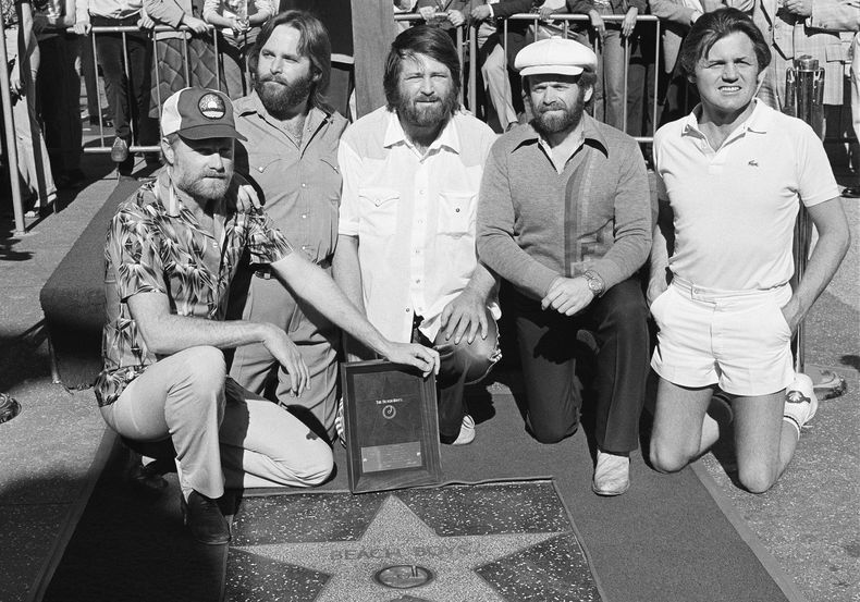 Los miembros de The Beach Boys, de izquierda a derecha, Mike Love, Carl Wilson, Brian Wilson, Al Jardine y Bruce Johnston, posan con su estrella en el Paseo de la Fama de Hollywood, durante una ceremonia en Los Ángeles el 30 de diciembre de 1980. (Foto AP/Lennox McLendon, File)