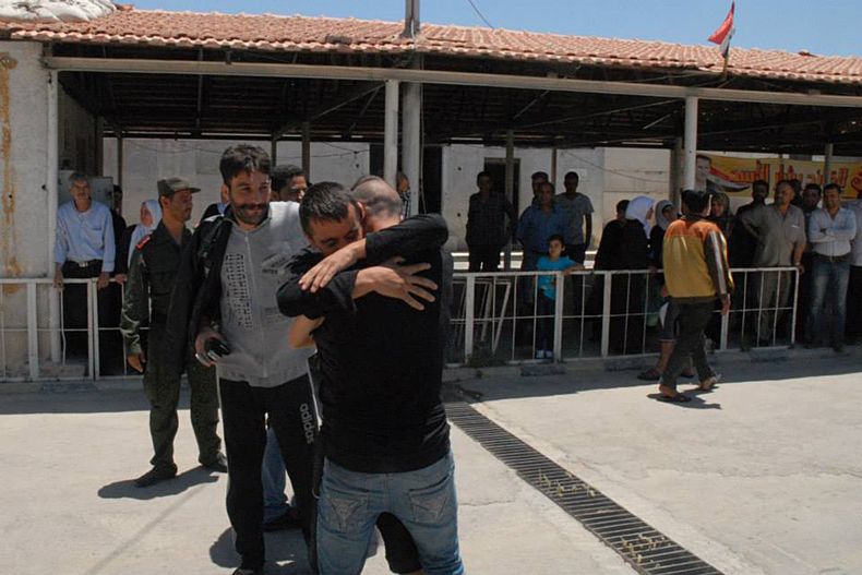 Foto proporcionada por la agencia estatal de noticias SANA donde se ve a un prisionero abrazar a un familiar despu&eacute;s de salir de la c&aacute;rcel en Damasco, Siria, el 11 de junio de 2014. El gobierno sirio liber&oacute; a unos 530 detenidos como p