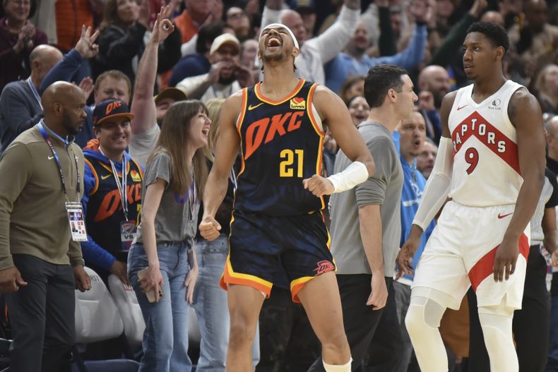 El base de los Raptors de Toronto RJ Barrett observa al base del Thunder de Oklahoma City Aaron Wiggins celebrando la victoria en doble tiempo extra en el encuentro del domingo 4 de febrero del 2024. (AP Foto/Kyle Phillips)