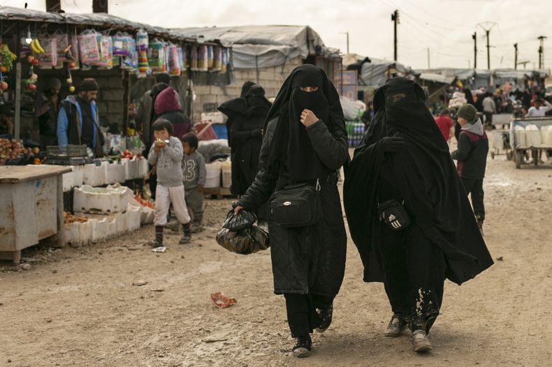 ARCHIVO - Dos mujeres compran en el mercado del campamento de al-Hol, que alberga a familiares de combatientes del grupo Estado Islámico, en la provincia de Hasakeh, Siria, el 31 de marzo de 2019. (AP Foto/Maya Alleruzzo, Archivo)