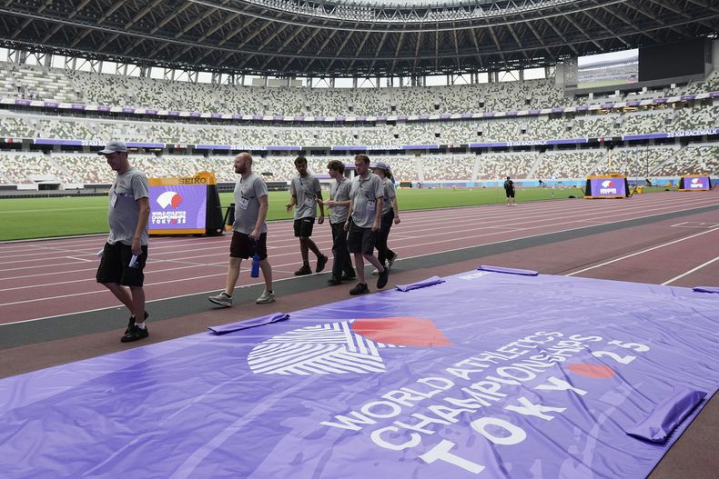 Voluntarios recorren la pista del Estadio Nacional de Tokio previo al Mundial de atletismo, el miércoles 10 de septiembre de 2025. (AP Foto/Ashley Landis)
