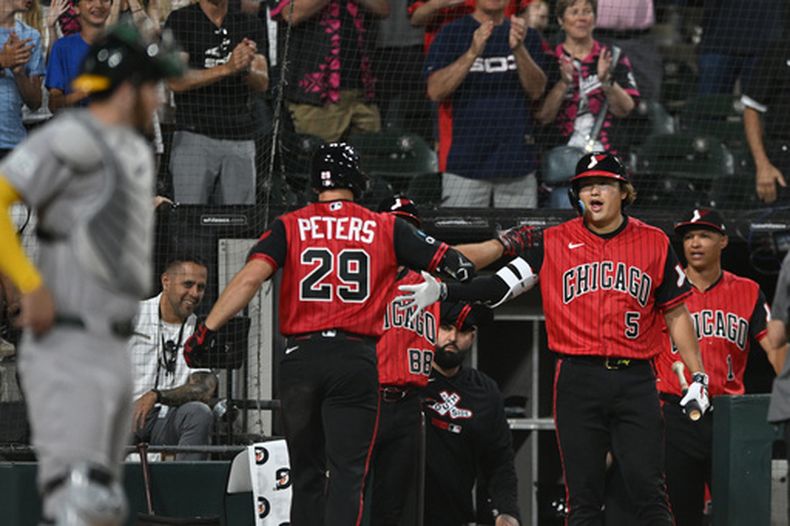 Tristan Peters, de los Medias Blancas de Chicago (29), celebra con su compañero de equipo Munetaka Murakami (5) en el dugout tras conectar un jonrón de dos carreras durante la séptima entrada de un partido de béisbol contra los Atléticos, en Chicago, el viernes 10 de julio de 2026. (Foto AP/Paul Beaty)