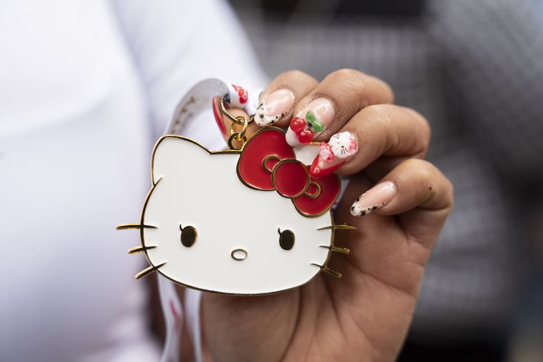Una fan del personaje japonés Hello Kitty muestra una medalla del personaje creado por Yuko Shimizu, durante la celebración del 50 aniversario, en la Ciudad de México, el domingo 13 de octubre de 2024. (AP Photo/Aurea Del Rosario)