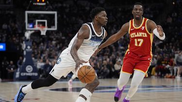 El base de los Timberwolves de Minnesota Anthony Edwards avanza hacia la canasta con el balón frene al alero de los Hawks de Atlanta Onyeka Okongwu en el encuentro del lunes 27 de enero del 2025. (AP Foto/Abbie Parr)