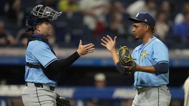 Logan Driscoll, izquierda, receptor de los Rays de Tampa Bay, celebracon el relevista Edwin Uceta, derecha, después de derrotar a los Guardianes de Cleveland en el juego de béisbol el viernes 13 de septiembre de 2024, en Cleveland. (AP Foto/Sue Ogrocki)