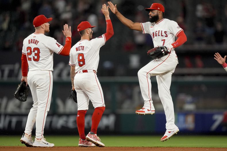 De izquierda a derecha, el segunda base de los Angelinos de Los Ángeles, Brandon Drury, el campocorto Zach Neto y el jardinero derecho Jo Adell celebran después de la victoria de su equipo contra los Cerveceros de Milwaukee el lunes 17 de junio de 2024, en Anaheim, California (AP Foto/Ryan Sun)