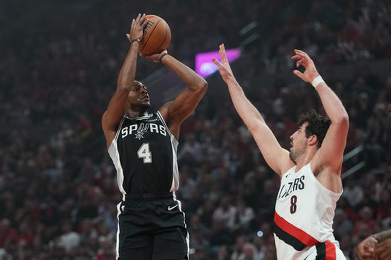 Deaaron Fox (4), de los Spurs de San Antonio, dispara sobre Deni Avdija (8), de los Trail Blazers de Portland, durante la segunda mitad del tercer juego de la primera ronda de los playoffs del balocnesto de la NBA, el viernes 24 de abril de 2026, en Portland. (AP Photo/Jenny Kane)