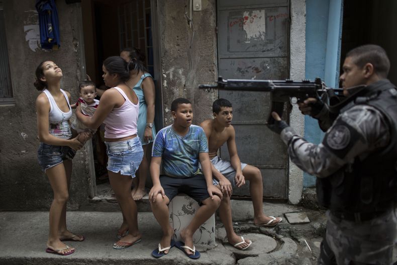Un pol&iacute;cia militar, derecha, patrulla una calle en la favela Mare en R&iacute;o de Janeiro el martes, 25 de marzo de 2014. (AP Photo/Felipe Dana)