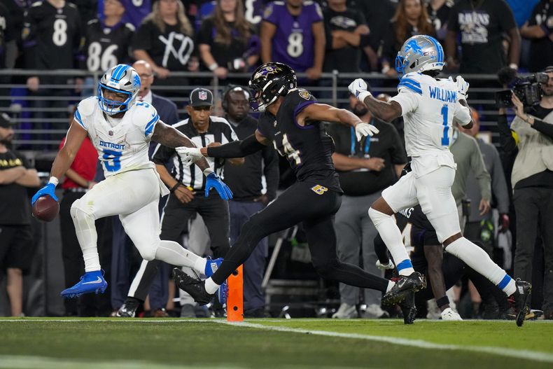 David Montgomery, izquierda, running back de los Lions de Detroit, anota un touchdown mientras el safety de los Ravens de Baltimore Kyle Hamilton (14) intenta detenerlo durante la segunda mitad del partido de la NFL del lunes 22 de septiembre de 2025, en Baltimore. (AP Foto/Stephanie Scarbrough)
