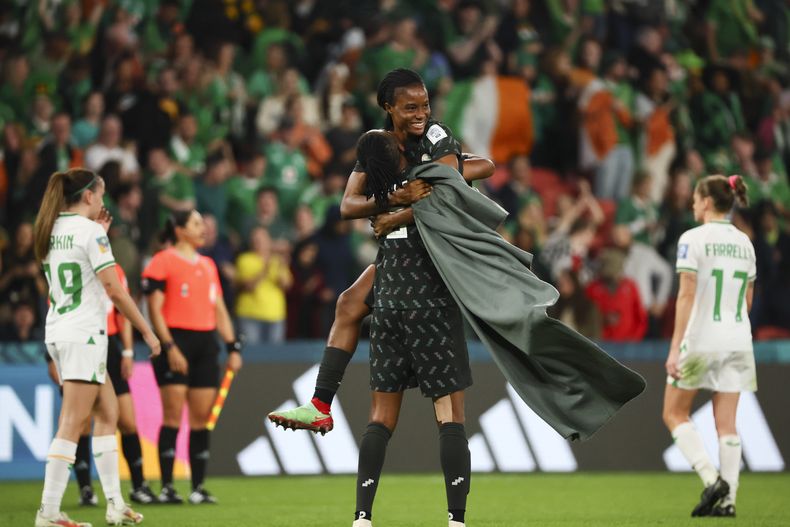 La nigeriana Blessing Demehin salta encima de su compañera Osinachi Ohale tras el empate 0-0 contra Irlanda, en el Mundial femenino, el lunes 31 de julio de 2023. (AP Foto/Tertius Pickard)