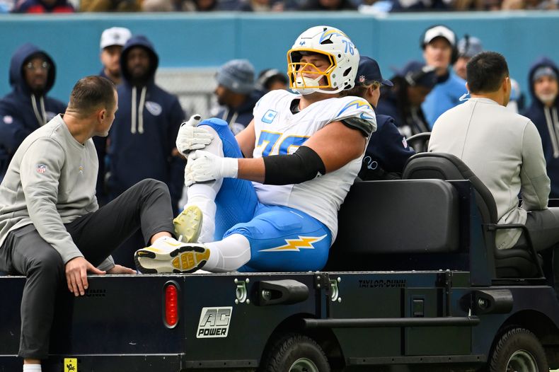 Joe Alt (76), tackle ofensivo de los Chargers de Los Ángeles, es llevado al vestuario en el carrito durante la primera mitad del partido de la NFL en contra de los Titans de Tennessee el domingo 2 de noviembre de 2025, en Nashville, Tennessee. (AP Foto/John Amis)