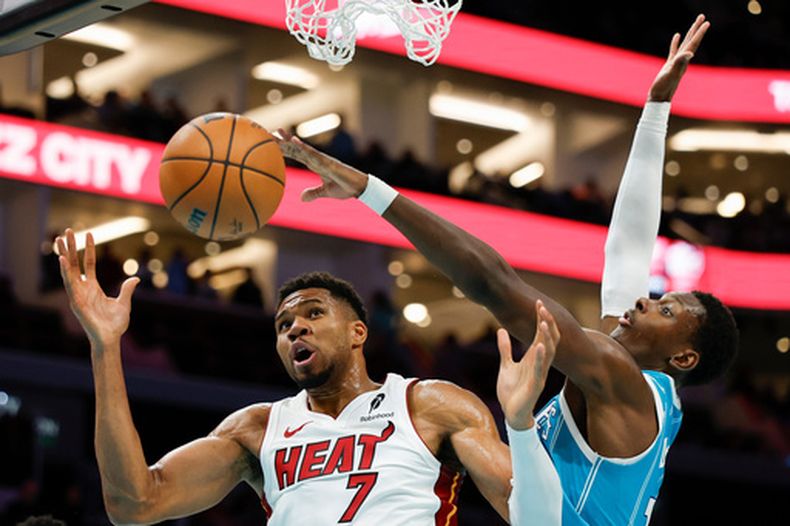 El delantero del Heat de Miami, Giannis Antetokounmpo (7), lucha por un rebote con el delantero de los Hornets de Charlotte, Moussa Diabate, durante la segunda mitad de un partido de básquetbol de la NBA en Charlotte, Carolina del Norte, el sábado 24 de octubre de 2026. (Foto AP/Nell Redmond)