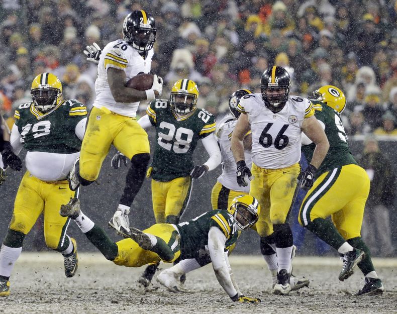 El jugador de los Steelers de Pittsburgh, LeVeon Bell, salta sobre el jugador de los Packers de Green Bay, Morgan Burnett, en un partido el domingo, 22 de diciembre de 2013, en Green Bay, Wisconsin.  (AP Photo/Mike Roemer)