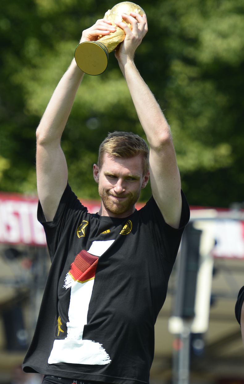 El jugador de la selecci&oacute;n de Alemania, Per Pertesacker, levanta el trofeo de campe&oacute;n del Mundial el 15 de julio de 2014 en Berl&iacute;n. Mertesacker anunci&oacute; su retiro de la selecci&oacute;n el 15 de agosto. (AP Photo/Jens Meyer, fil