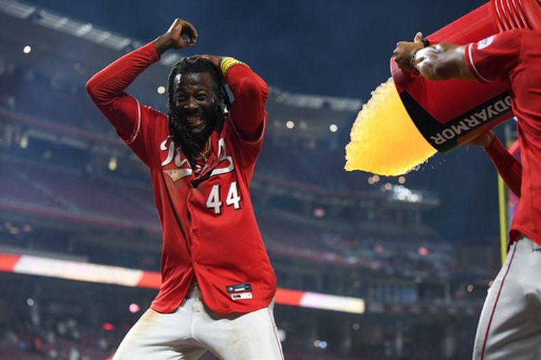 Elly De La Cruz, de los Rojos de Cincinnati, busca evitar recibir un baño de sus compañeros de equipo después de pegar el hit decisivo para dejar tendidos en el terreno a los Cardenales de San Luis, en el juego de béisbol de Grandes Ligas del lunes 17 de agosto de 2026, en Cincinnati. (AP Foto/Tanner Pearson)