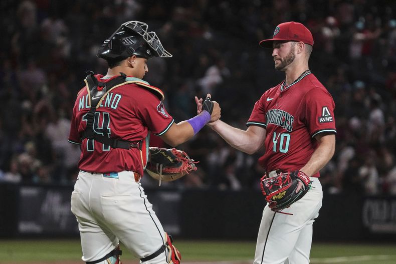 El venezolano Gabriel Moreno, de los Diamondbacks de Arizona, festeja con el pitcher Bryce Jarvis, tras vencer a los Marineros de Seattle, en el juego del martes 10 de junio de 2025 (AP Foto/Rick Scuteri)