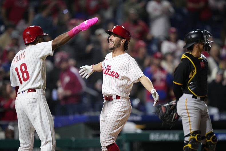 Garrett Stubbs, centro, y Johan Rojas, izquierda, de los Filis de Filadelfia, celebran después del cuadrangular de Stubbs de tres carreras durante la cuarta entrada del juego de béisbol en contra de los Piratas de Pittsburgh, el miércoles 27 de septiembre de 2023, en Filadelfia. (AP Foto/Matt Slocum)