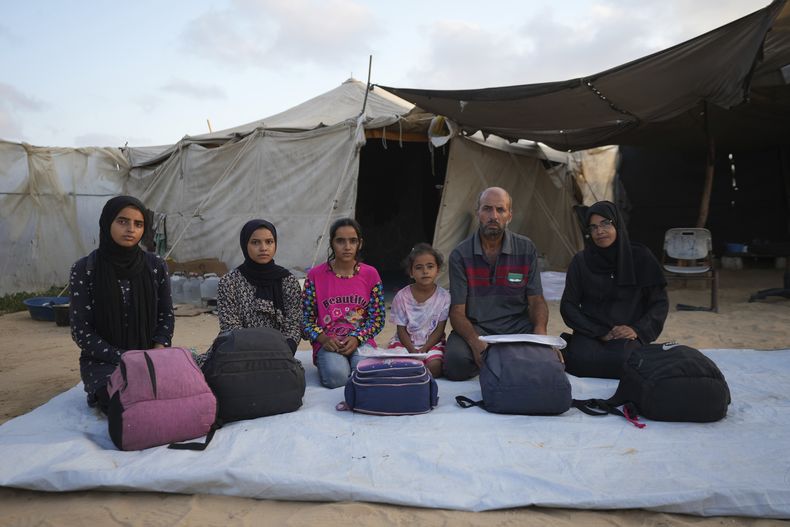 Miembros de la familia Abu Jarad posan para una foto en su campamento de carpas, donde viven tras verse desplazados cinco veces desde el inicio de la guerra entre Israel y Hamás, en Muwasi, Franja de Gaza, el viernes 13 de septiembre de 2024. (AP Foto/Abdel Kareem Hana)