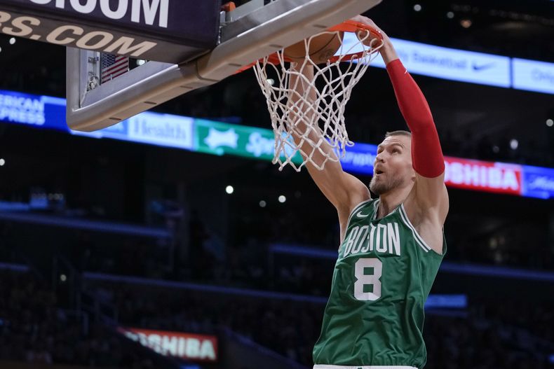 El pívot de los Celtics de Boston Kristaps Porzingis clava el balón en el encuentro de Navidad ante los Lakers de Los Ángeles el lunes 25 de diciembre del 2023. (AP Foto/Ryan Sun)