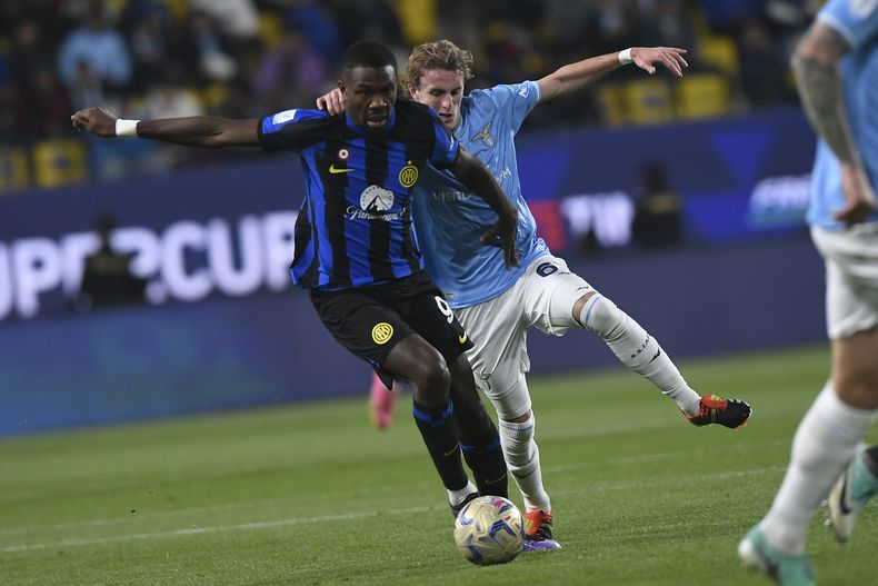 Marcus Thuram del Inter de Milán pelea por el balón con Nicolo Rovella de la Lazio en la semifinal de la Super Copa de Italia en el Estadio Al Awwal Park en Riad, Arabia Saudí el viernes 19 de enero del 2024. (AP Foto)