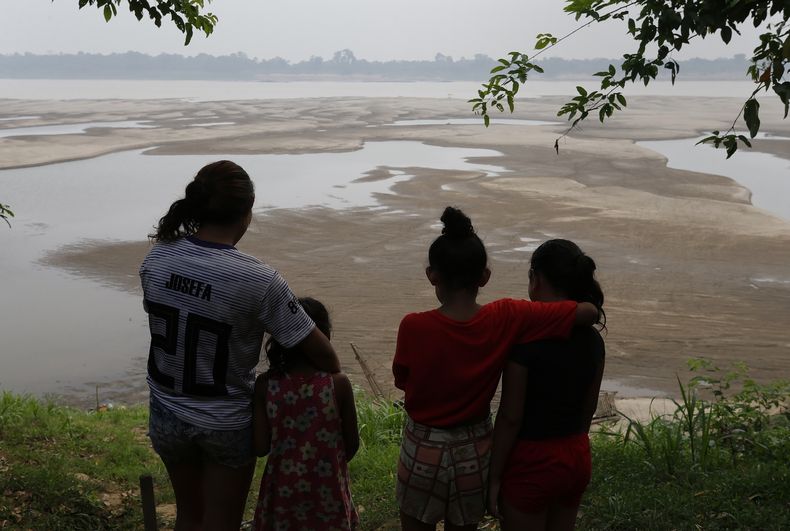 Un grupo de personas mira hacia el río Madeira en Humaita, estado de Amazonas, Brasil, el 7 de septiembre del 2024. (AP foto/Edmar Barros)