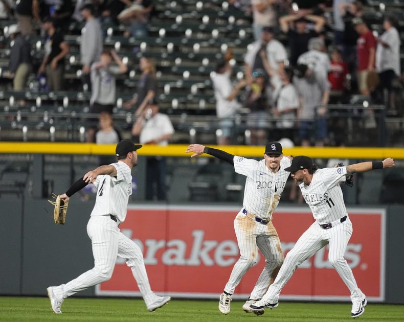 El jardinero izquierdo de los Rockies de Colorado Sean Bouchard, el jardinero central Brenton Doyle y el jardinero derecho Jake Cave, de izquierda a derecha, celebran la victoria del equipo en el juego de béisbol contra los Guardianes de Cleveland el miércoles 29 de mayo de 2024, en Denver. (AP Foto/David Zalubowski)