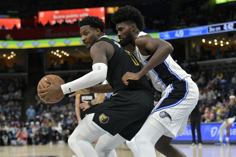 Jaren Jackson Jr., alero de los Grizzlies de Memphis, conduce el balón frente a Jonathan Isaac, del Magic de Orlando, en el duelo del viernes 26 de enero de 2024 (AP Foto/Brandon Dill)