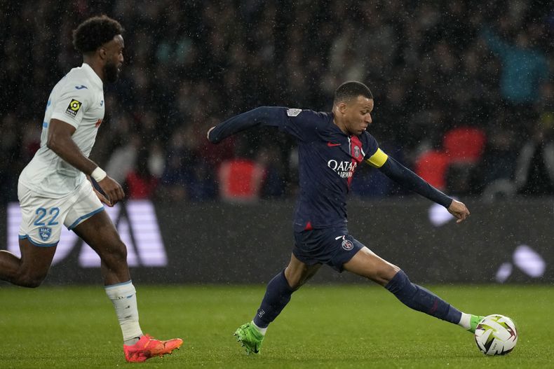 Kylian Mbappé, del PSG, se escapa de Yoann Salmier, de Le Havre, durante el partido de la Liga 1 de francia entre Paris Saint-Germain y Le Havre en el Parque de los Príncipes, en París, el sábado 27 de abril de 2024. (AP Foto/Thibault Camus)