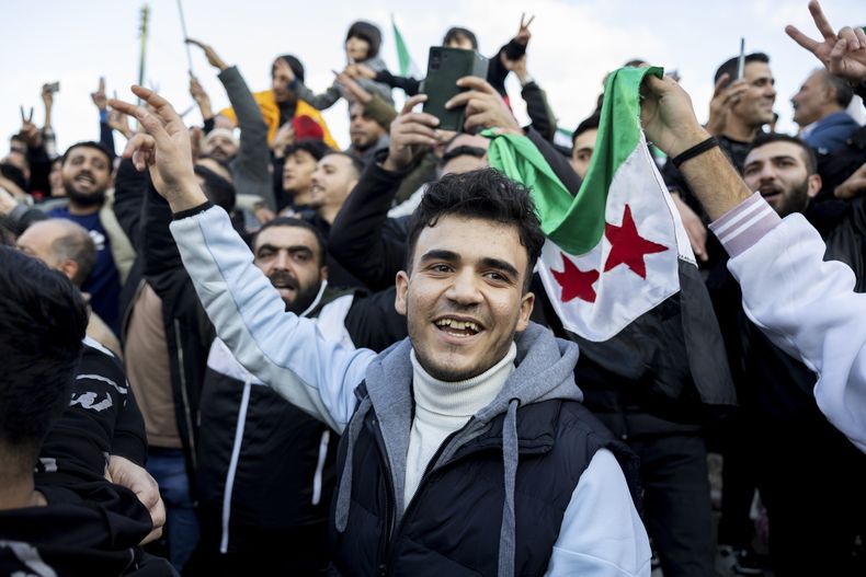 Un grupo de personas celebra la caída del presidente sirio Bashar Assad en Atenas, Grecia, el 8 de diciembre del 2024. (AP foto/Yorgos Karahalis)
