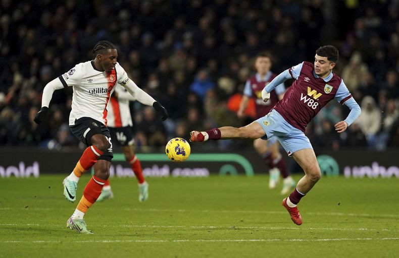 Amarii Bill del Luton Town (izquierda), y Zeki Amdouni de Burney disputan e balón durante el partido de la Liga Inglesa en Turf Moor, Burnley, Inglaterra, el viernes 12 de enero de 2024. (Martin Rickett/PA via AP)