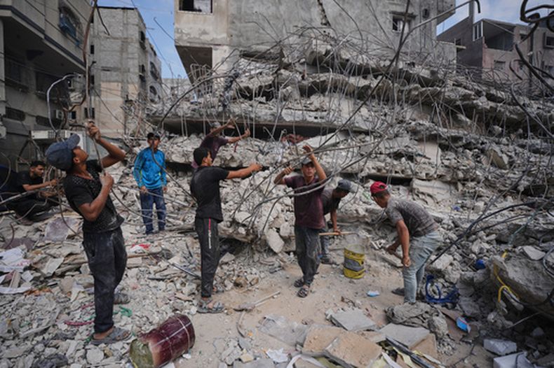 Varios palestinos retiran hierro de los escombros de edificios destruidos por ataques aéreos israelíes durante la guerra con Hamás para repararlo y reciclarlo para la construcción, elaborar tiendas de campaña, o venderlo, en Ciudad de Gaza, el domingo 16 de agosto de 2026. (AP Foto/Jehad Alshrafi)