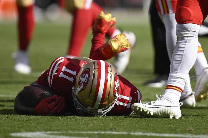 El receptor abierto de los 49ers de San Francisco , Brandon Aiyuk (11), permanece en el campo después de ser golpeado durante la primera mitad de un partido de fútbol americano de la NFL contra los Chiefs de Kansas City en Santa Clara, California, el domingo 20 de octubre de 2024. (AP Foto/Eakin Howard)