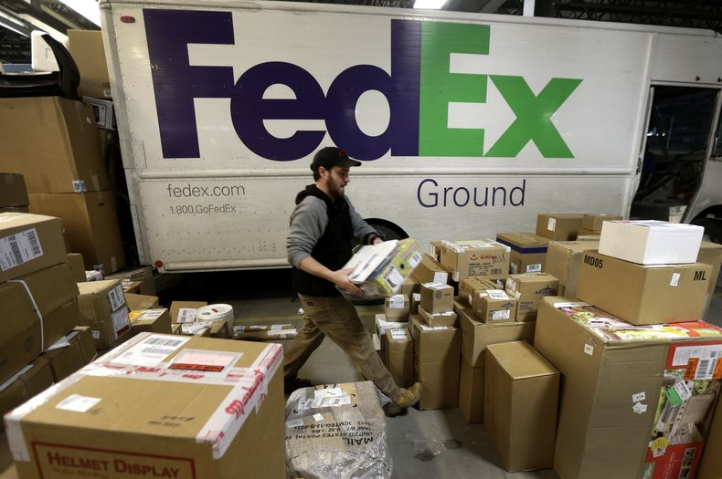 ARCHIVO - En esta imagen del 16 de diciembre de 2013, Chris Addison maneja paquetes antes de cargar un cami&oacute;n de entregas en el centro de distribuci&oacute;n de FedEx en Kansas City, Missouri. (Foto AP/Charlie Riedel)