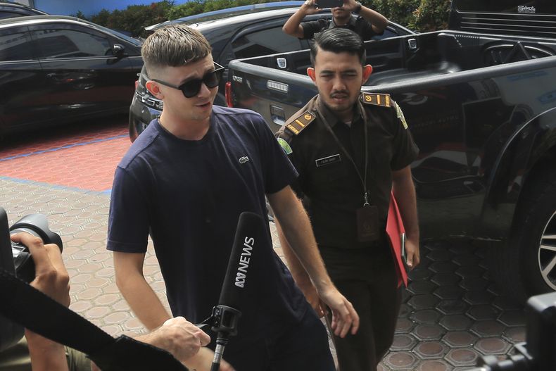Bodhi Mani Risby-Jones de Queensland, Australia (izq), llega a la oficina de inmigración en Meulaboh, Aceh, Indonesia, el 7 de junio de 2023. (Foto AP /Sultan Ikbal Abiyyu)