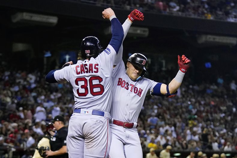 Enrique Hernández, derecha, de Medias Rojas de Boston, celebra su cuadrangular de dos carreras en contra de los Diamondbacks de Arizona, con Triston Casas (36) durante la cuarta entrada del juego de béisbol, el viernes 26 de mayo de 2023, en Phoenix. (AP Foto/Ross D. Franklin)