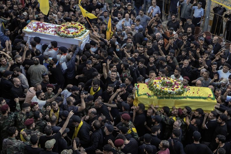 Dolientes cargan los ataúdes de las víctimas que murieron el martes luego de unas explosiones de bíperes, durante su funeral en Beirut, Líbano, el miércoles 18 de septiembre de 2024. (AP Foto/Bilal Hussein)