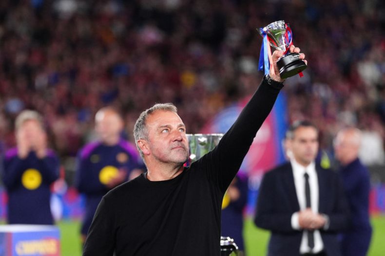 El entrenador del Barcelona Hansi Flick levanta su premio después de que el equipo conquistó La Liga con una victoria ante el Real Madrid el domingo 10 de mayo del 2026. (AP Foto/Joan Mateu Parra)