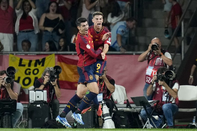 Álvaro Morata celebra con Gavi (derecha) tras anotar el primer gol de España en la victoria 2-0 ante Escocia en las eliminatorias de la Eurocopa, el jueves 12 de octubre de 2023, en Sevilla. (AP Foto/José Bretón)