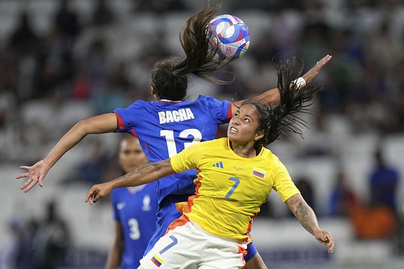La colombiana Manuela Pavi (7) pugna el balón con la francesa Selma Bacha en el partido del torneo de fútbol femenino de los Juegos Olímpicos, el jueves 25 de julio de 2024, en Decines, Francia. (AP Foto/Laurent Cipriani)
