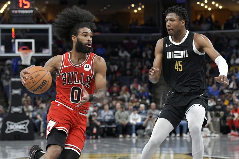 El escolta de los Bulls de Chicago, Coby White (0), conduce contra el alero de los Grizzlies de Memphis, GG Jackson (45), durante la primera mitad del partido de baloncesto de la NBA, el jueves 8 de febrero de 2024, en Memphis, Tennessee.
