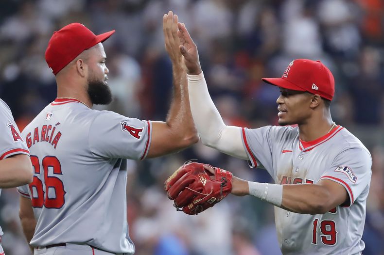 El cerrador de los Angelinos de Los Ángeles, Luis García, a la izquierda, y el segunda base Kyren Paris (19) celebran su victoria por 2-1 sobre los Astros de Houston después del partido de béisbol el miércoles 22 de mayo de 2024 en Houston. (AP Foto/Michael Wyke)