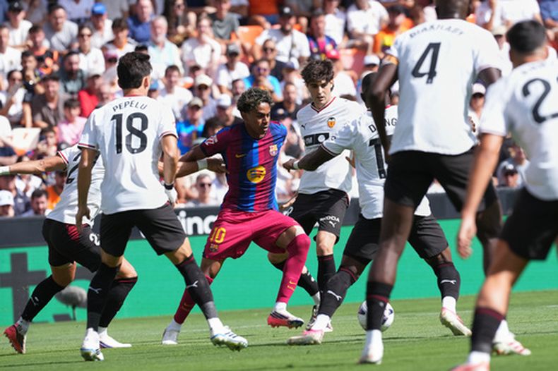 El delantero del Barcelona, Lamine Yamal, lucha por el balón durante un partido de fútbol de la Liga Española entre el Valencia y el Barcelona en Valencia, España, el domingo 6 de septiembre de 2026. (Foto AP/Alberto Saiz)