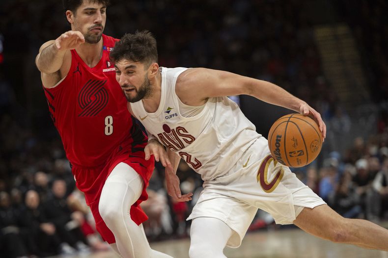 Ty Jerome (2), de los Cavaliers de Cleveland, lleva el balón ante la presión de Deni Avdija (8), de los Trail Blazers de Portland, durante la segunda mitad del juego de baloncesto de la NBA, el domingo 2 de marzo de 2025, en Cleveland. (AP Foto/Phil Long)